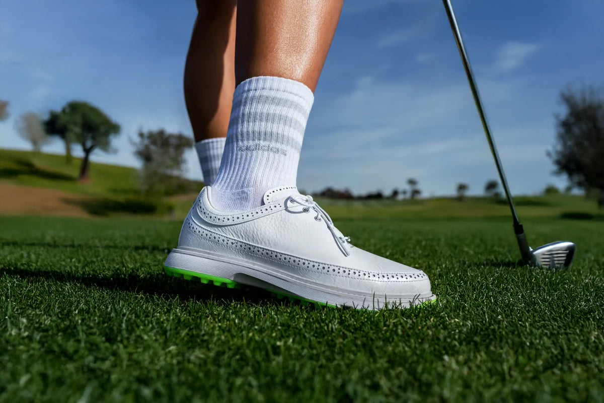 detail of the Adidas MC80 spikeless golf shoe used by a player in a golf field