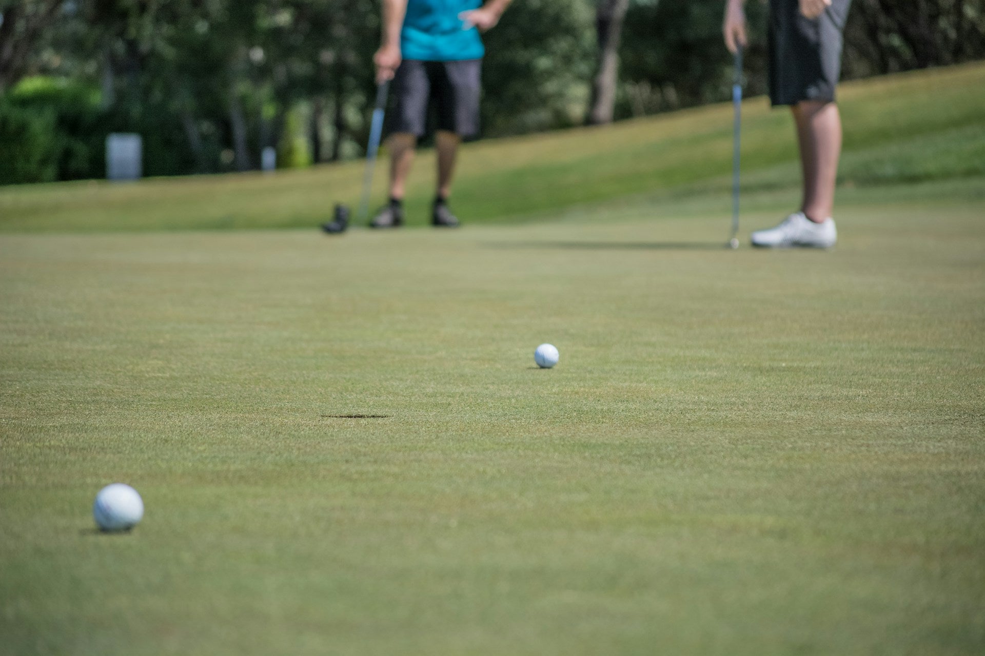 detail of golfers wearing waterproof golf shoes during a game