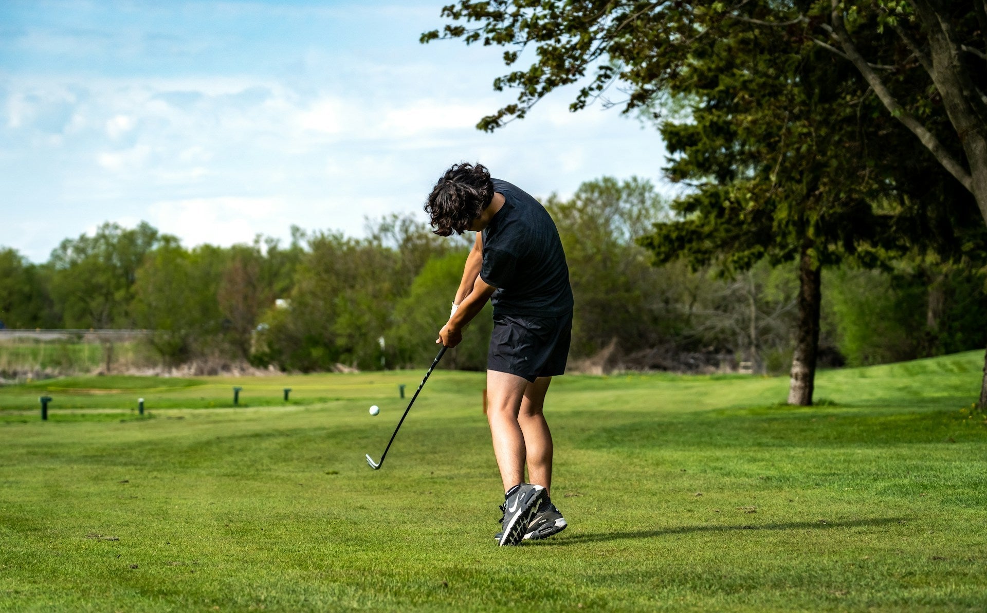 golfer hitting a draw shot in a golf field