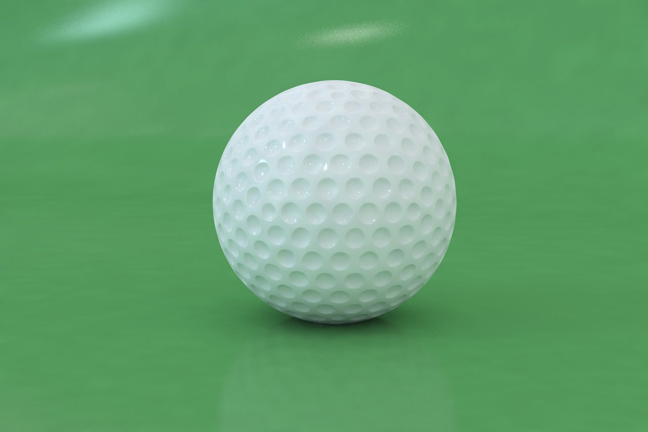blank golf ball over green floor to be customized