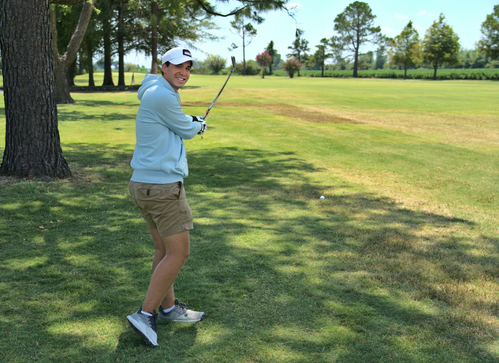 golf player wearing a light blue golf hoodie during a game