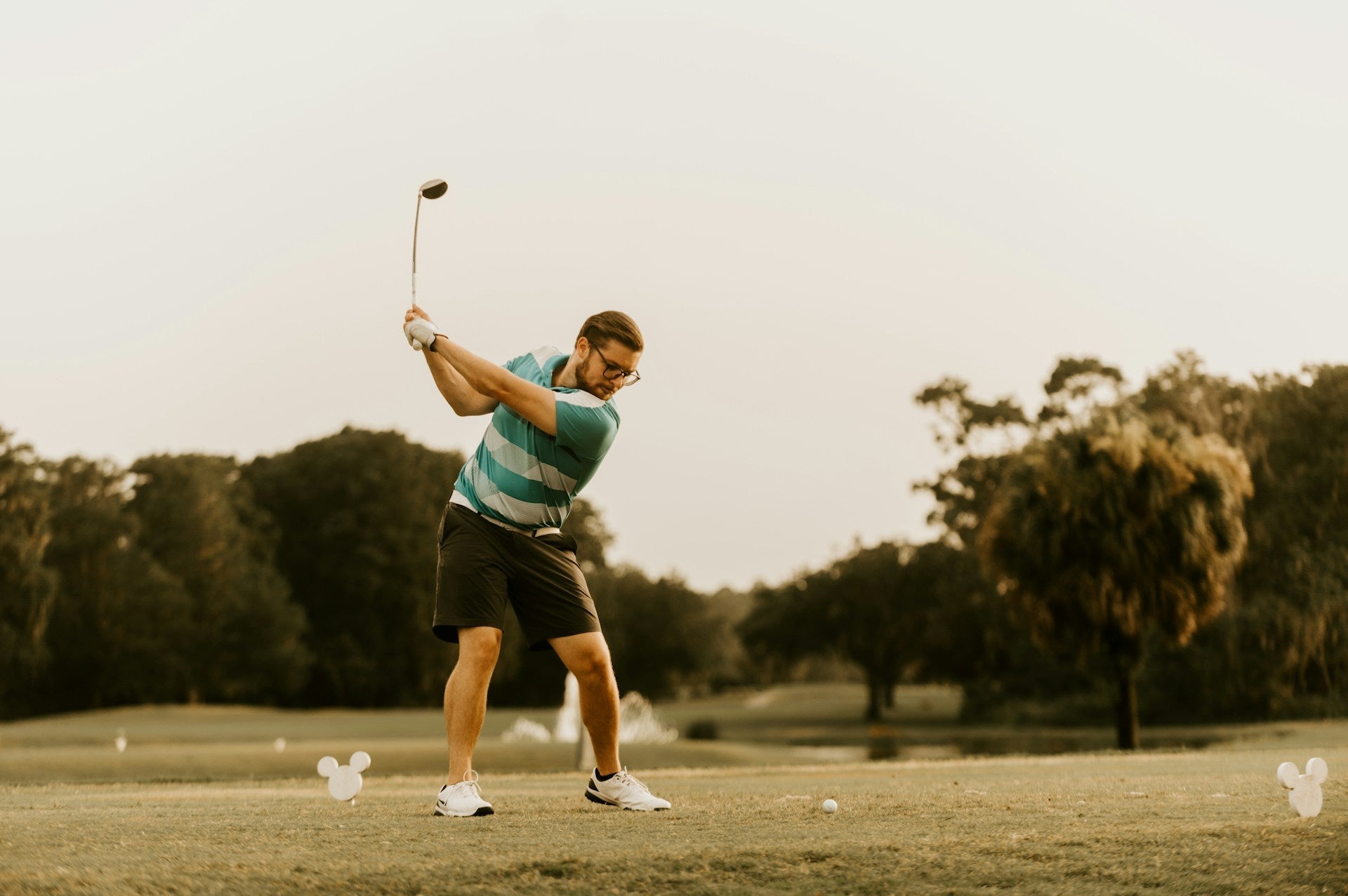 golf player hitting a driver with proper stance and swing