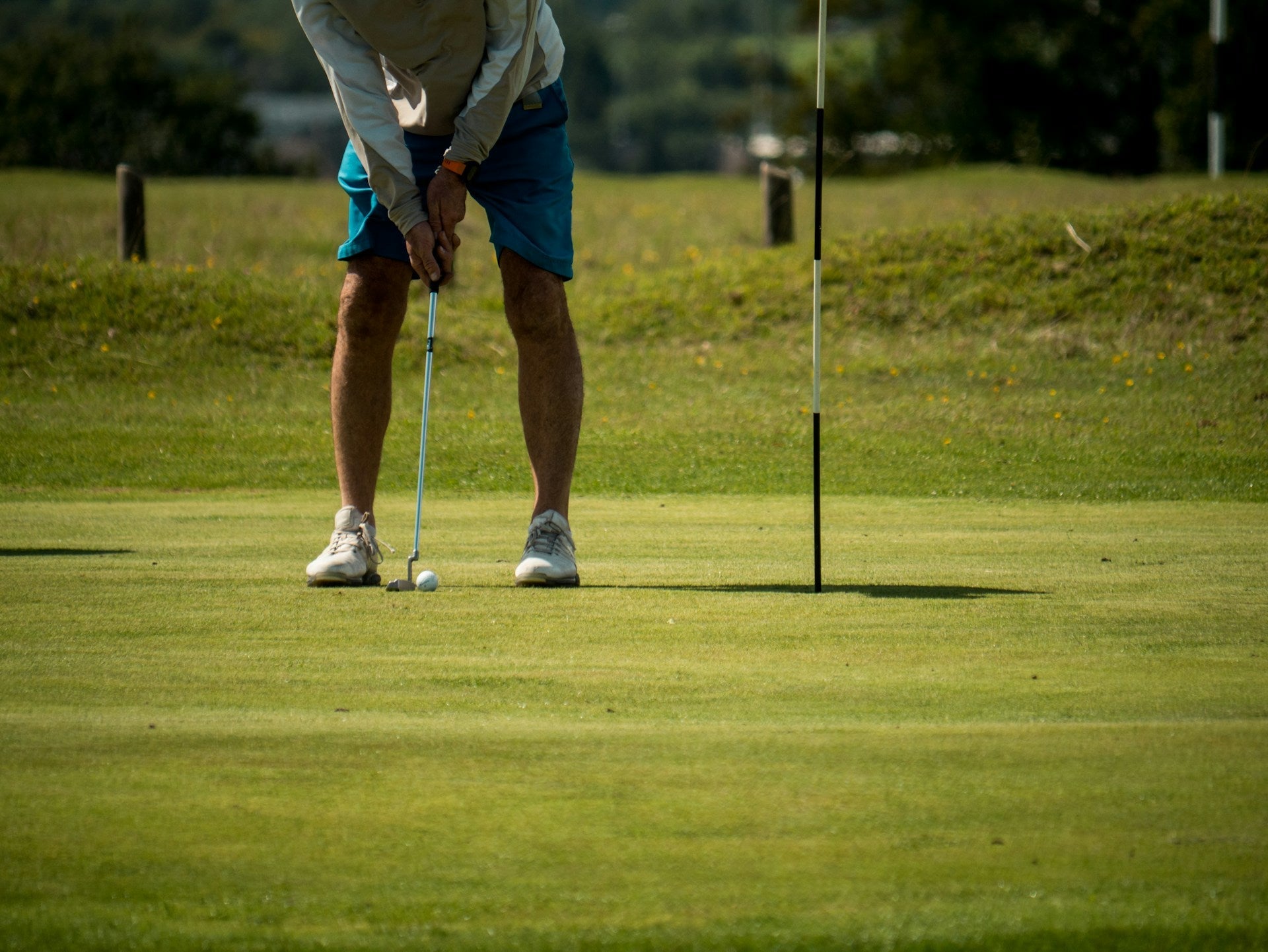 golf player griping a golf club with neutral grip about to put