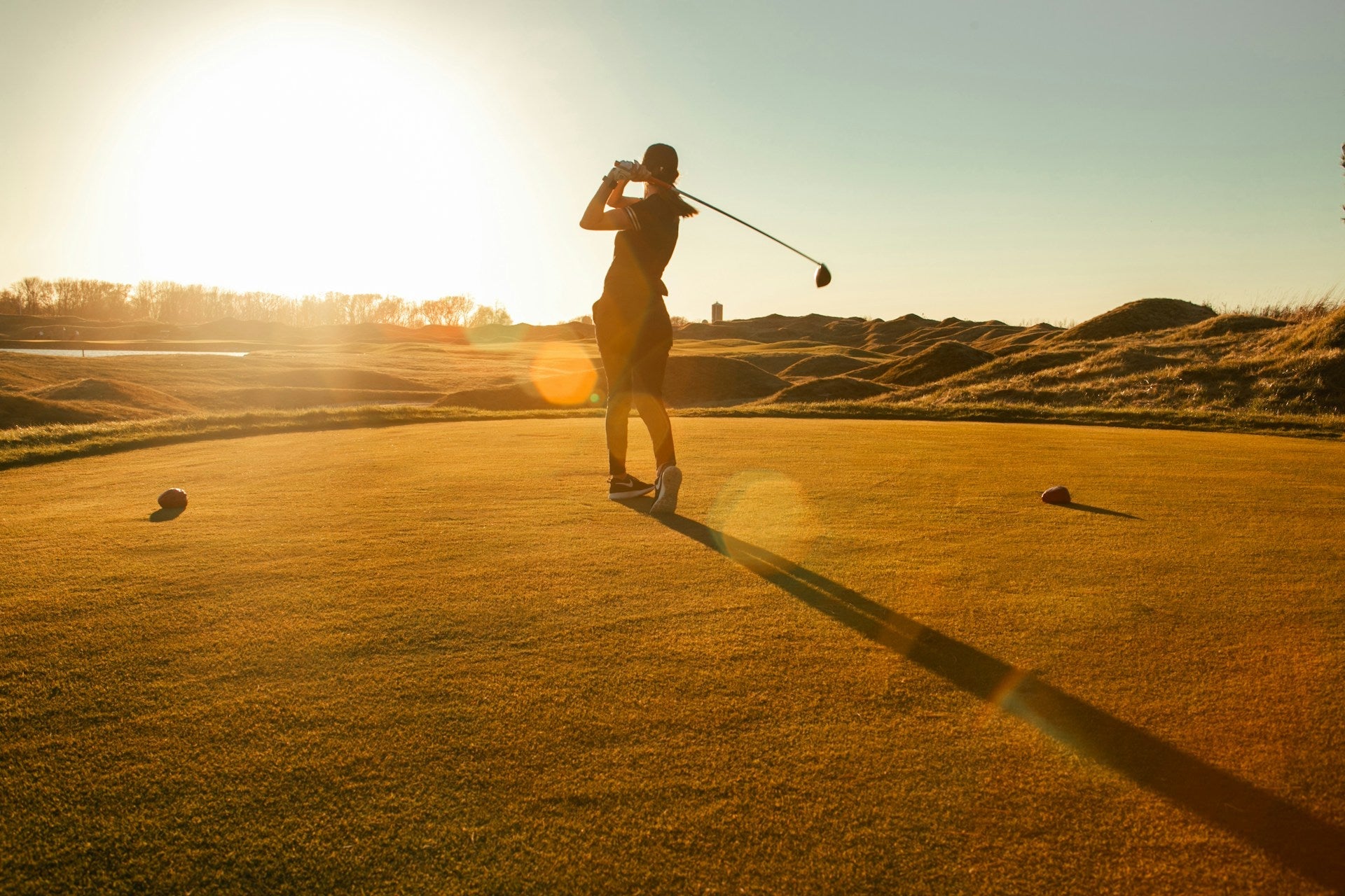 women golf player playing golf in the sunset with a women's golf club set