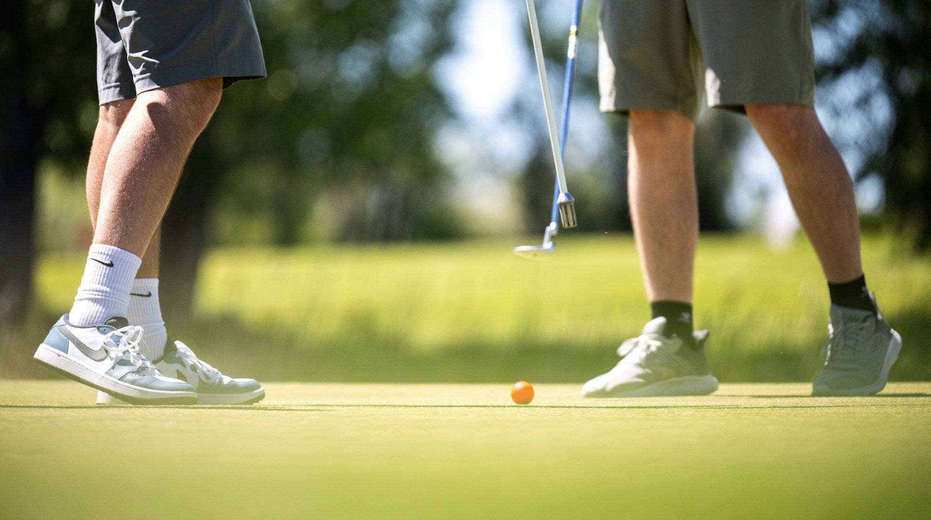 detail of the golf shoes of two golf players in a golf field