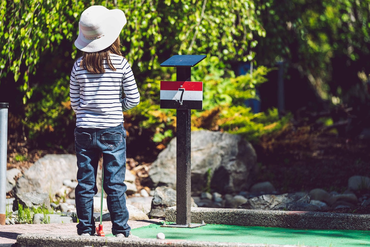 children playing golf with a junior set of golf clubs