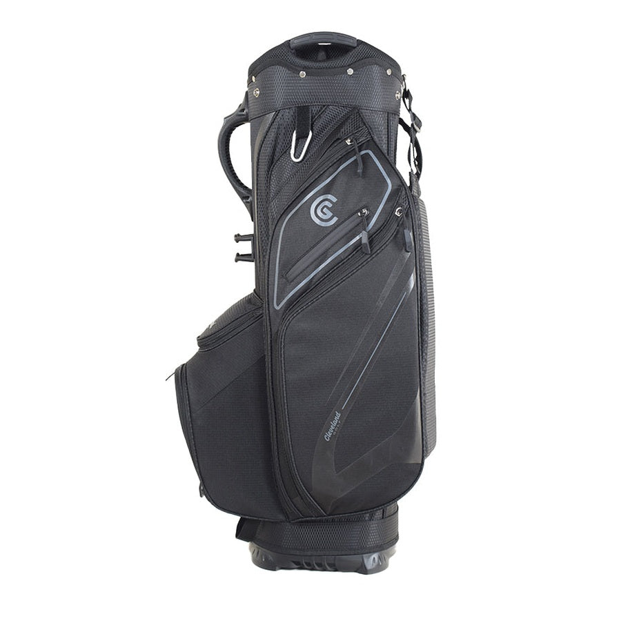 The Cleveland Golf Lightweight Cart Bag in black features multiple zippered compartments, an insulated cooler pocket, velour-lined valuables pocket, side handle, and shoulder straps. It stands upright on a white background.