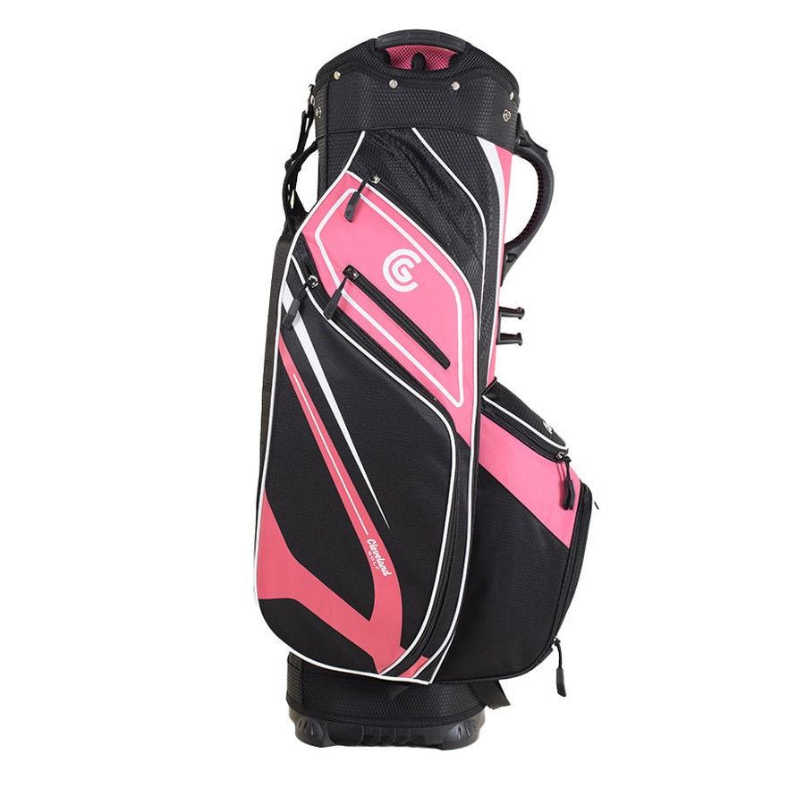 The Cleveland Golf Lightweight Cart Bag in pink, black, and white stands upright on a white background. It features multiple zippered pockets, including a velour-lined valuables pocket, insulated cooler pocket, and a top handle.