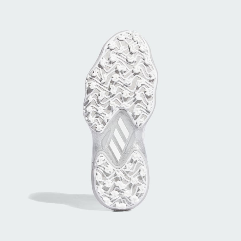 The image displays the sole of the Adidas Codechaos Ladies 25 Spikeless Golf Shoes in white, featuring an intricate textured tread pattern and three diagonal stripes at the arch, set against a plain light gray background.