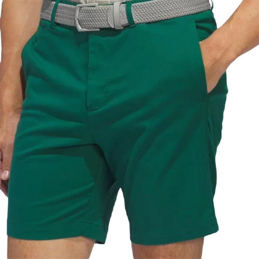 A person wearing Adidas Go-To Five-Pocket Golf Shorts in bright green, paired with a light gray woven belt and one hand in their pocket—shown from waist to mid-thigh for versatile style on any occasion.