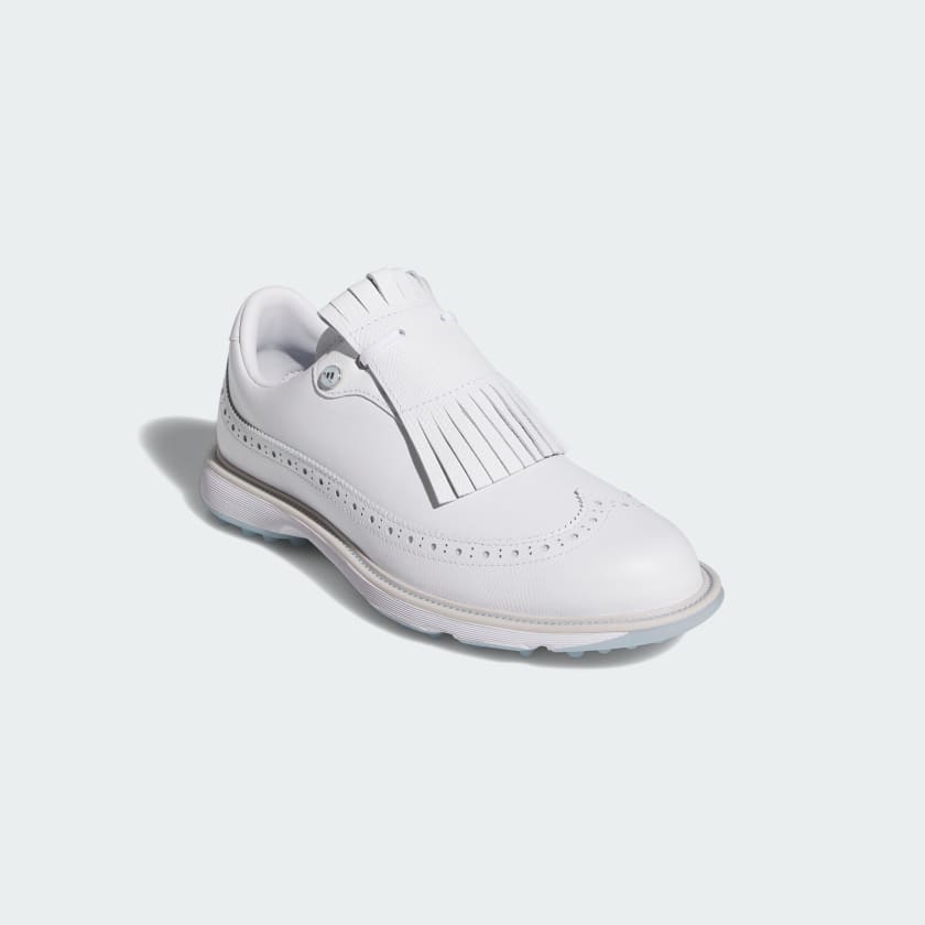 The Adidas MC Zoysia Ladies Spikeless Golf Shoes in white feature decorative perforations and a removable fringe kiltie over the laces, displayed on a plain light background.