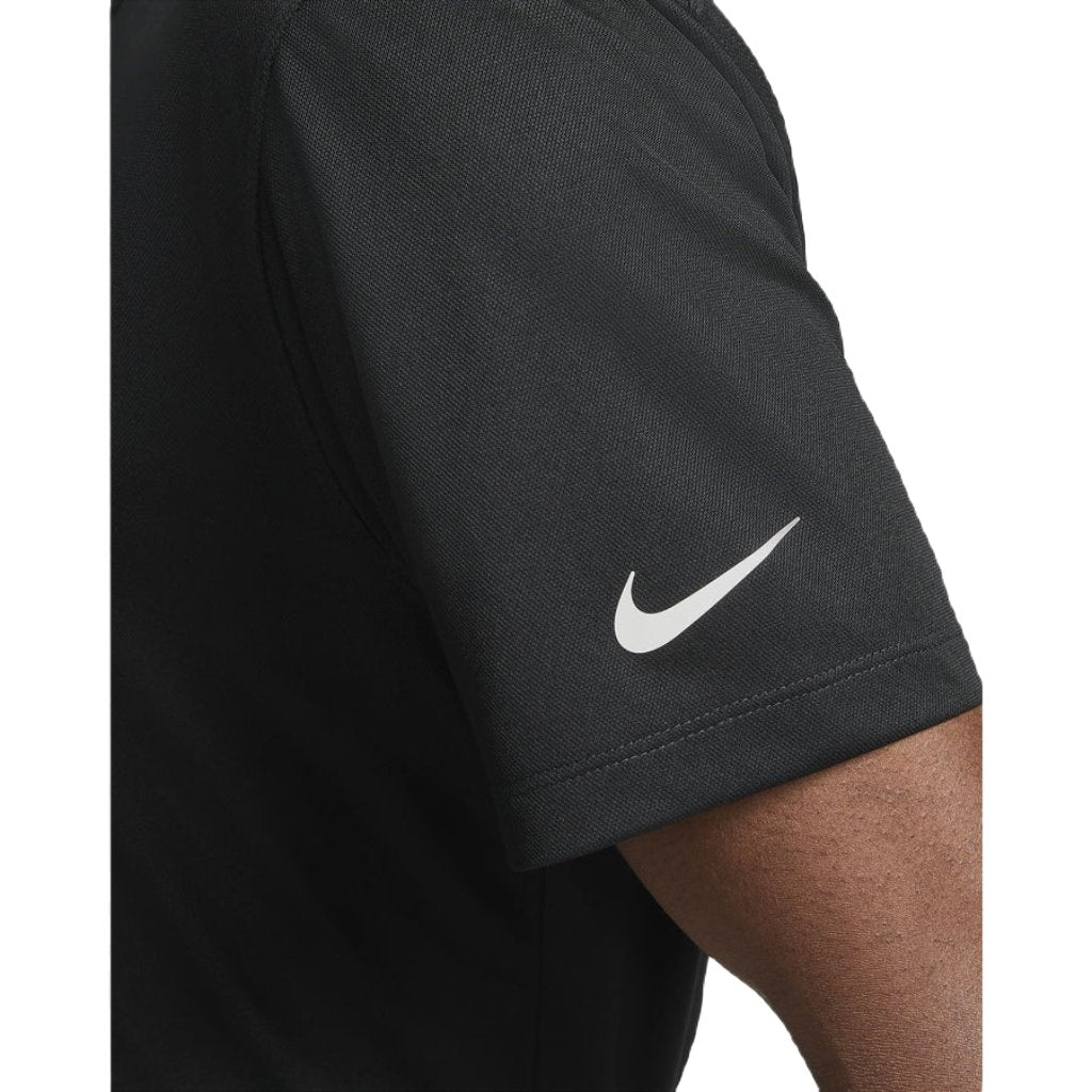 Close-up of a person wearing the Nike Dri-FIT Victory Men's Golf Shirt, featuring a course/event logo and white swoosh on the sleeve. The comfortable Dri-FIT fabric is highlighted against a white background. Final Sale.