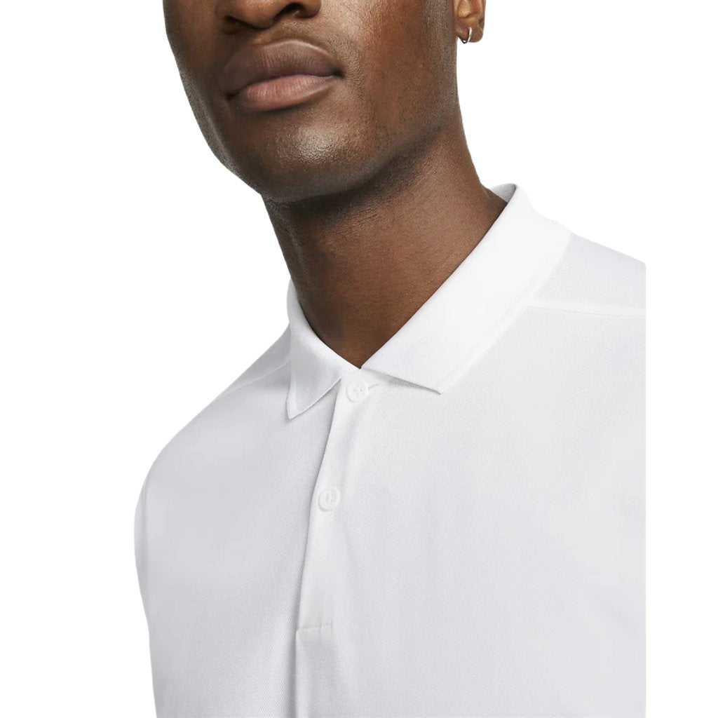 A person wears a Nike Dri-FIT Victory Men's Golf Shirt featuring a course/event logo. Only their lower face, neck, and upper torso are visible against a plain white background.