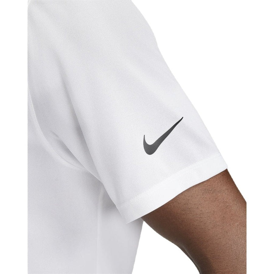 Close-up of a person wearing the Nike Dri-FIT Victory Men's Golf Shirt - Course/Event Logo - Final Sale, white with a black Swoosh on the sleeve. Only part of the arm and shoulder are visible against a white background.
