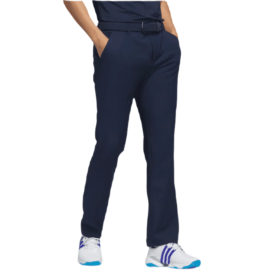 Only the lower body is visible: a person stands hands in pockets, wearing Adidas Ultimate365 Pants - Blue made from recycled materials, matched with a belt and white sneakers with blue and purple accents on a white background.