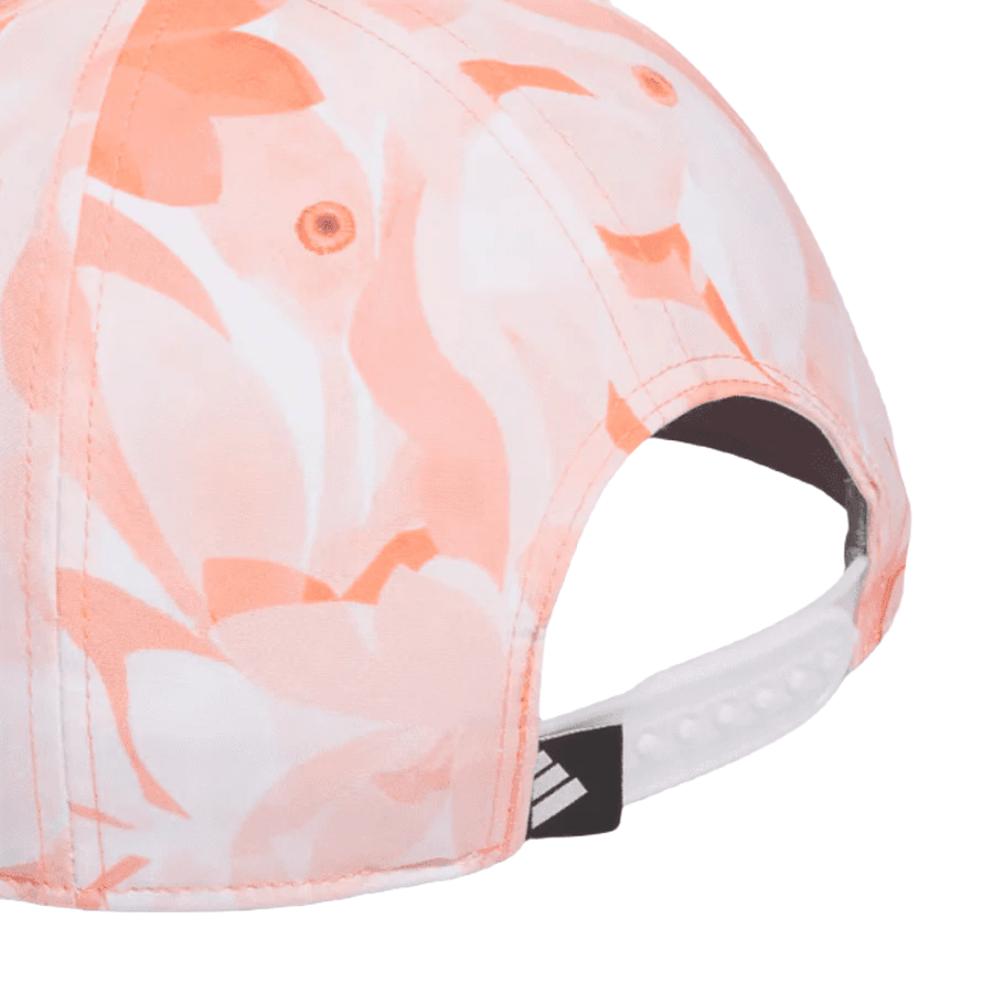 A close-up of the Adidas Orange Season Opener Golf Hat, featuring a peach and white abstract floral pattern, white adjustable snap closure, small Adidas logo tag by the strap, and made from recycled materials.