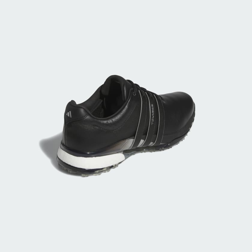 The Adidas Tour360 25 Spikeless Golf Shoes in black, with silver stripes and a white sole with a 3D Traxion outsole, are shown from the back right side against a light gray background.