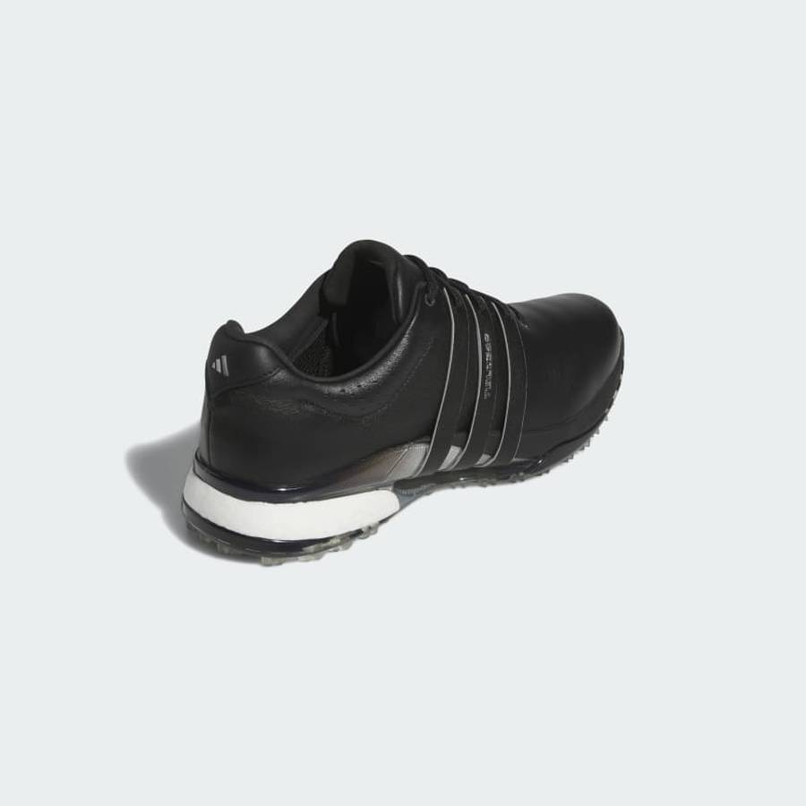 The Adidas Tour360 25 Spikeless Golf Shoes in black, with silver stripes and a white sole with a 3D Traxion outsole, are shown from the back right side against a light gray background.