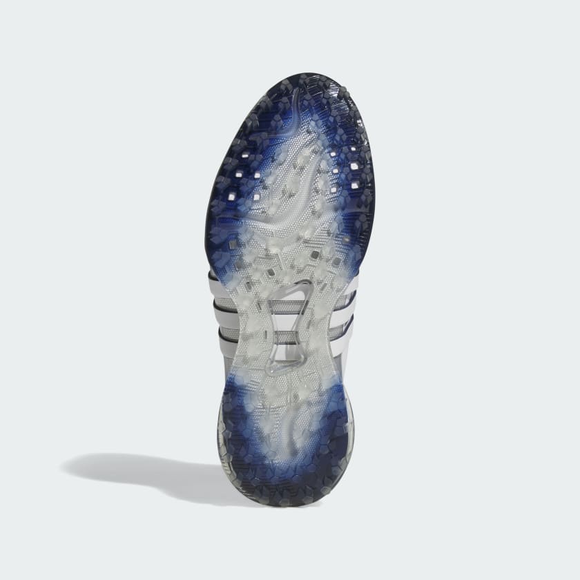 The image shows the sole of the Adidas Tour360 25 Spikeless Golf Shoes in grey, featuring a textured, translucent 3D Traxion outsole with blue and black accents and a white BOOST midsole with black stripes on the sides.