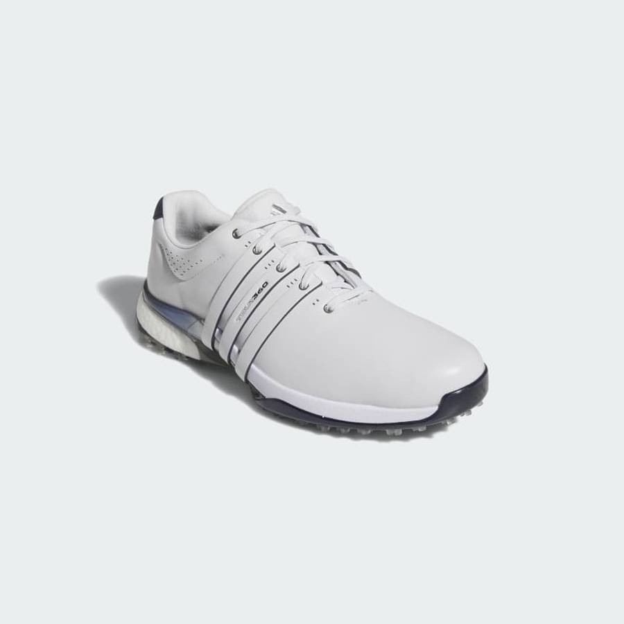 The Adidas Tour360 25 Spikeless Golf Shoes in grey feature a white upper with dark gray accents, multiple side stripes, a textured 3D Traxion outsole, and a low-cut design, shown on a light gray background.