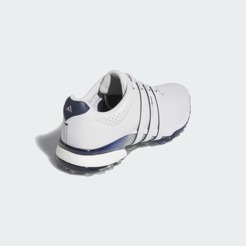 The Adidas Tour360 25 Spikeless Golf Shoes in grey feature navy accents and laces, a BOOST midsole, and are shown from the back left against a light background.