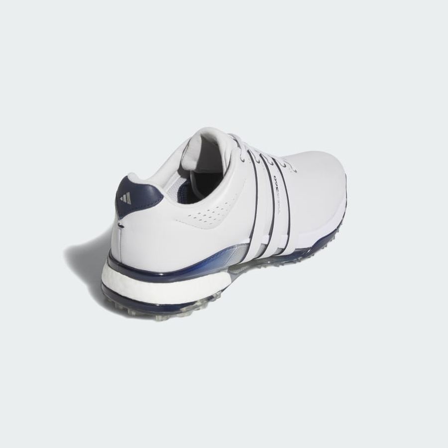 The Adidas Tour360 25 Spikeless Golf Shoes in grey feature navy accents and laces, a BOOST midsole, and are shown from the back left against a light background.