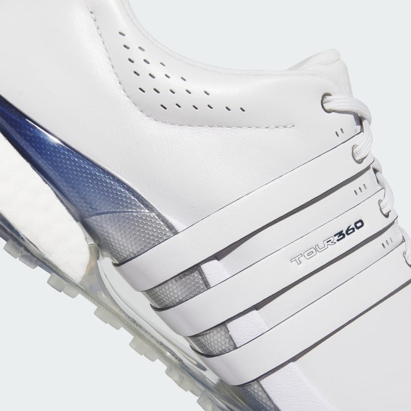 Close-up of the Adidas Tour360 25 Spikeless Golf Shoes in grey, featuring side details with three white stripes, laces, perforations near the collar, and a transparent blue and white BOOST midsole section.