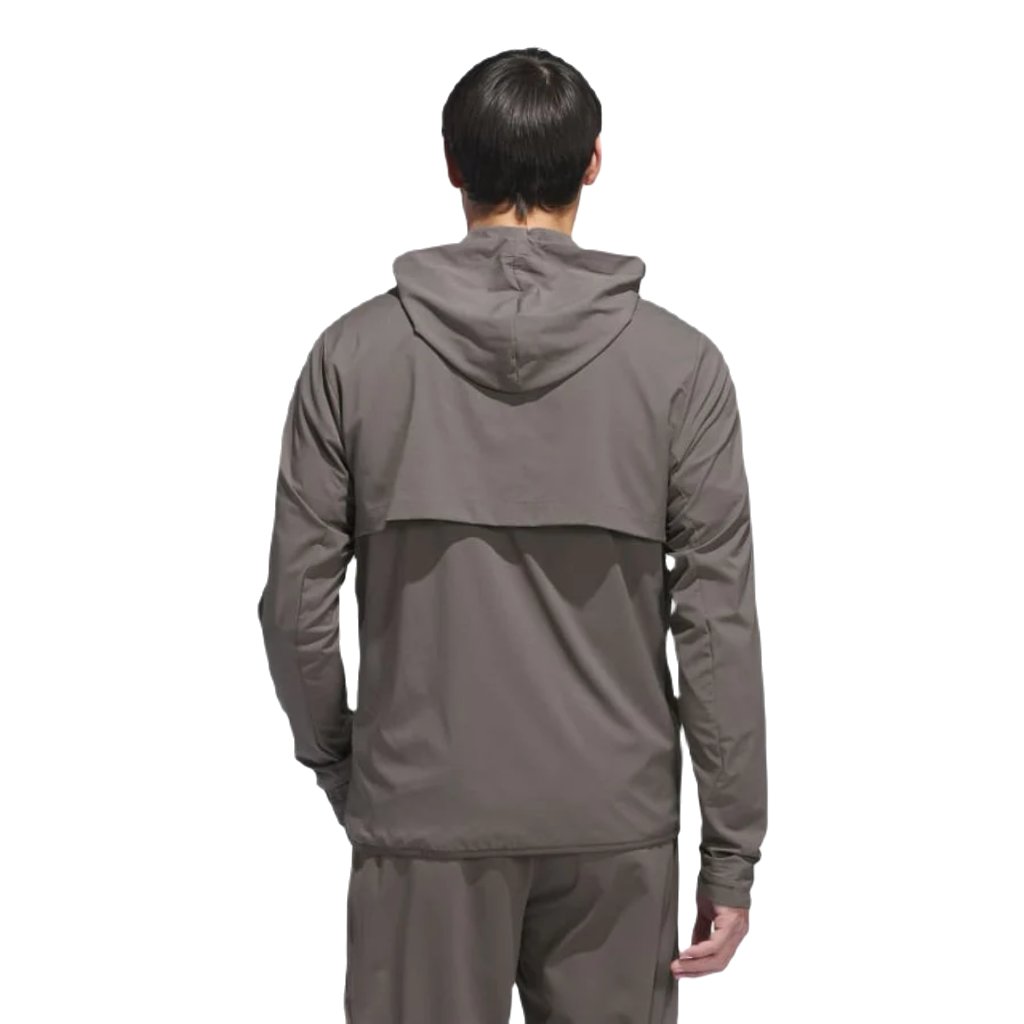 A person is shown from the back wearing an Adidas Ultimate365 WIND.RDY Convertible Jacket in brown, made from recycled materials, standing against a plain white background.
