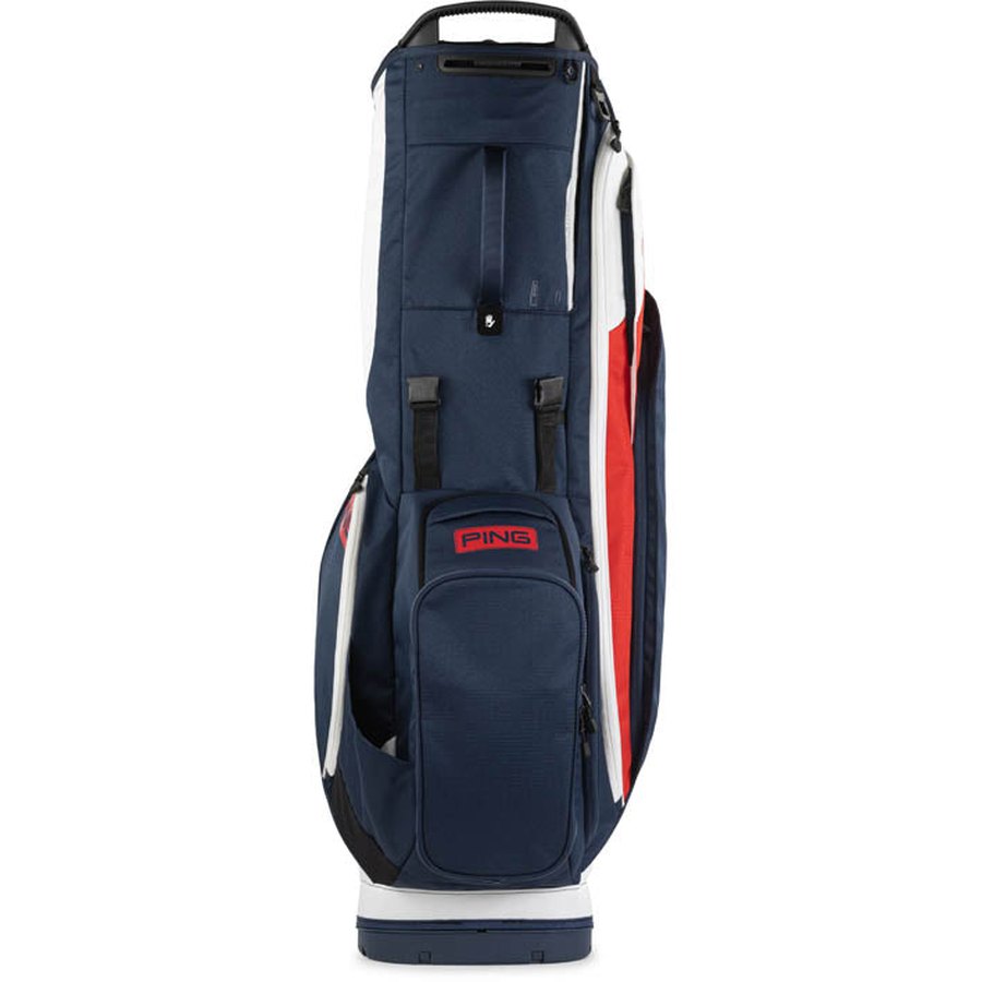 The Ping Hoofer 231 Golf Carry Bag stands upright in navy, white, and red, features 16 zippered pockets, a lightweight build, and a top handle.