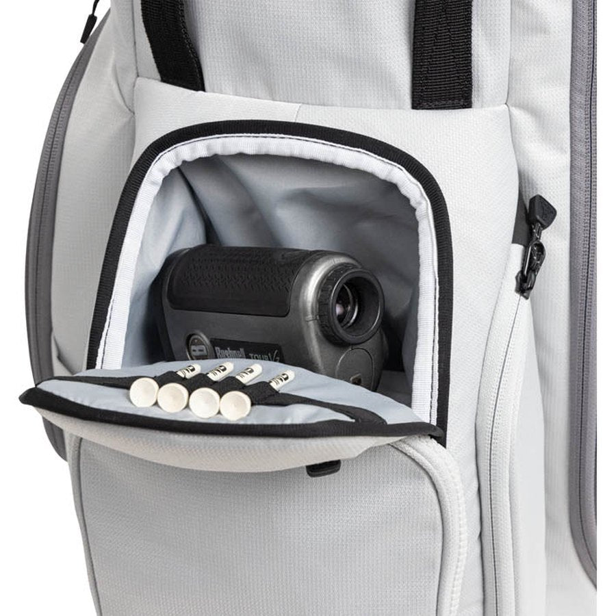 A close-up of a Ping Hoofer 231 Golf Carry Bag's lightweight gray pocket holding a black golf rangefinder and five white tees neatly arranged on the inner flap.
