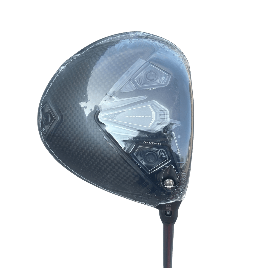 A close-up of the Cobra Darkspeed Tour Issue Long Drive LS Driver with a carbon fiber finish, adjustable fade/neutral weights, and a HZRDUS Green shaft, still wrapped in protective plastic.