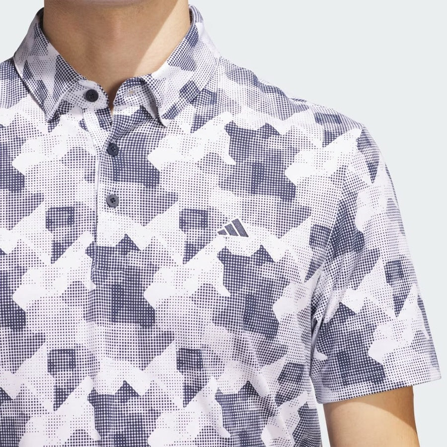 A person wearing the Adidas 2025 Go-To Printed Polo Shirt, featuring a black and white geometric pattern and a small chest Adidas logo. Made with recycled materials; only their upper torso and neck are shown.