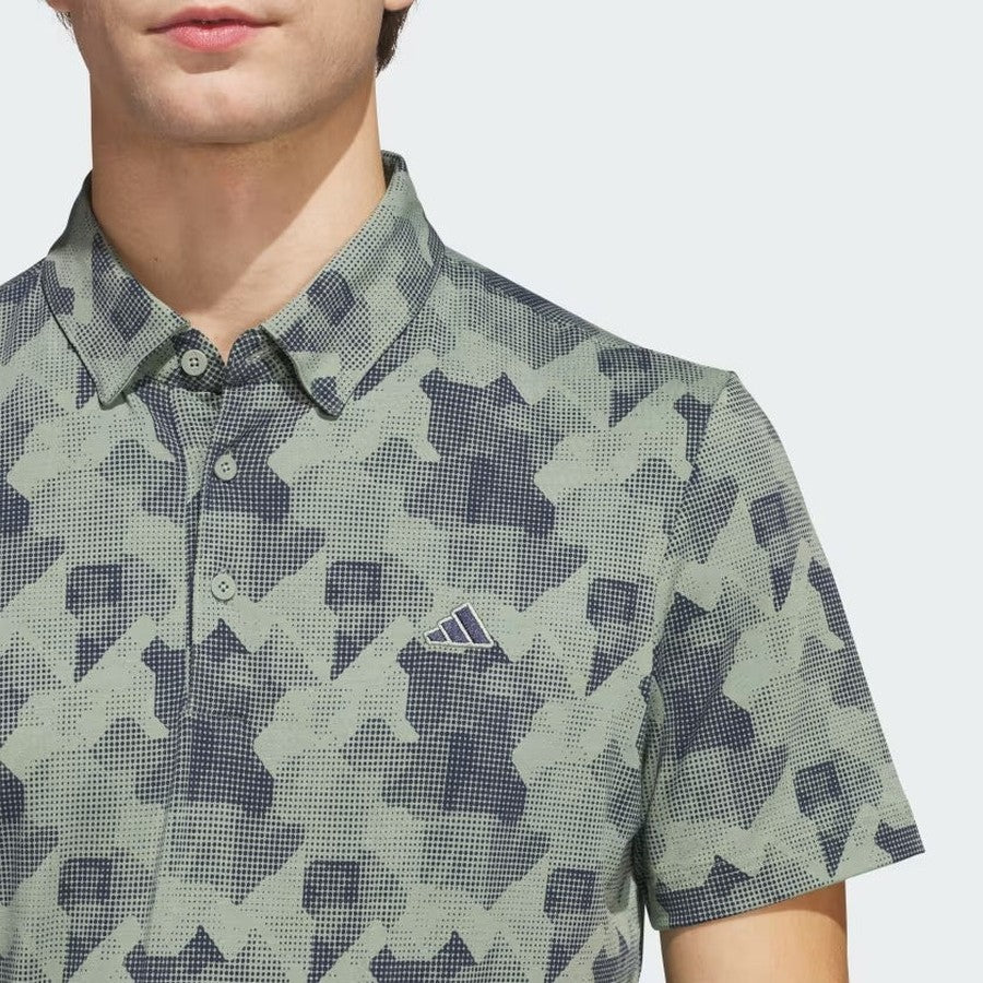 A person models the Adidas 2025 Go-To Printed Polo Shirt in green and navy pattern, made with recycled materials, shown from shoulders to mouth against a plain light background.