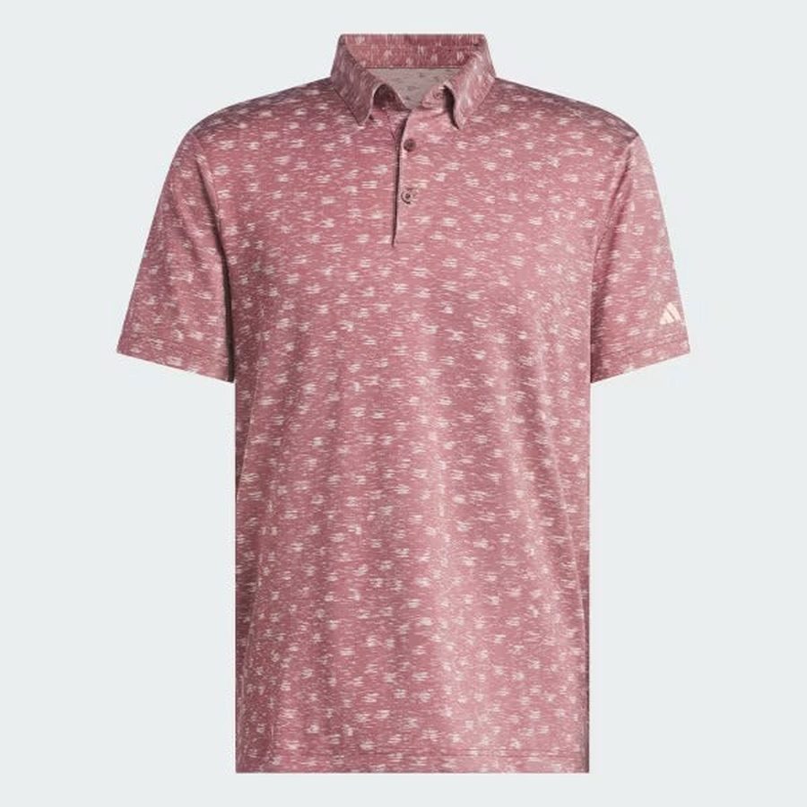 The Adidas Ultimate365 Novelty Polo Shirt in burgundy features short sleeves, a button-up design, a subtle white abstract pattern, is made from recycled materials, and displays a small adidas logo on the left sleeve.