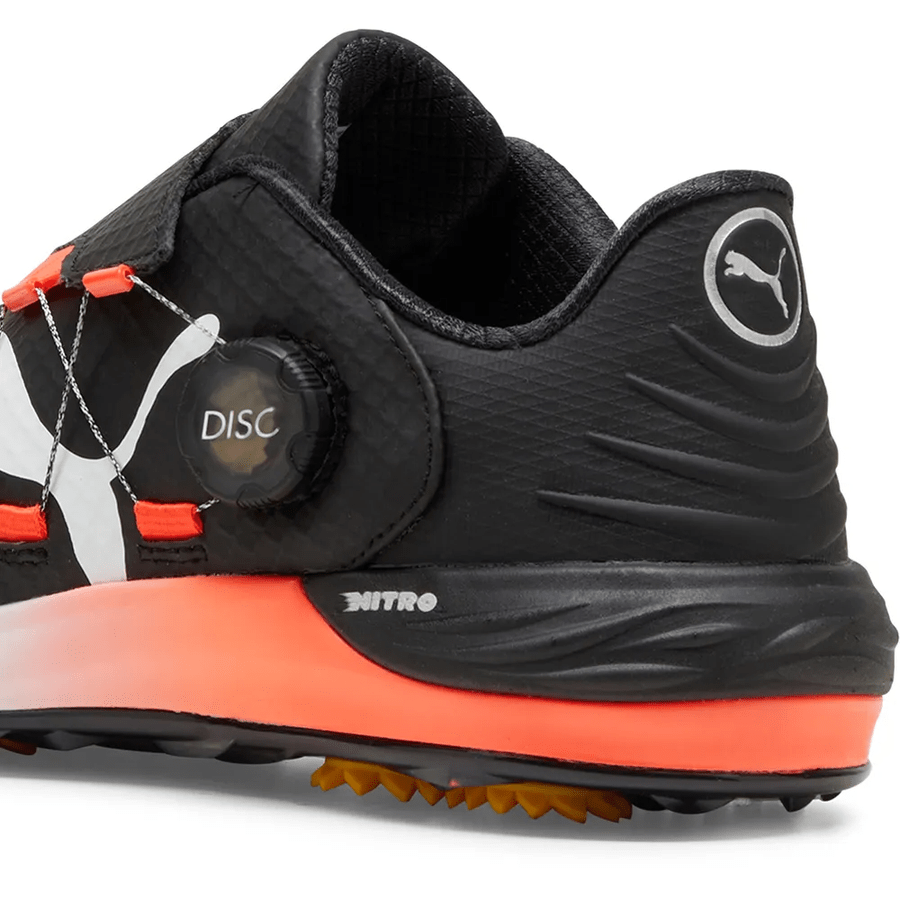 A close-up of the PUMA Phantomcat Nitro Disc Golf Shoes - Black highlights orange accents, the disc tightening system, NITRO foam technology, and Puma logos on the heel and side with NITRO branding above the orange midsole.