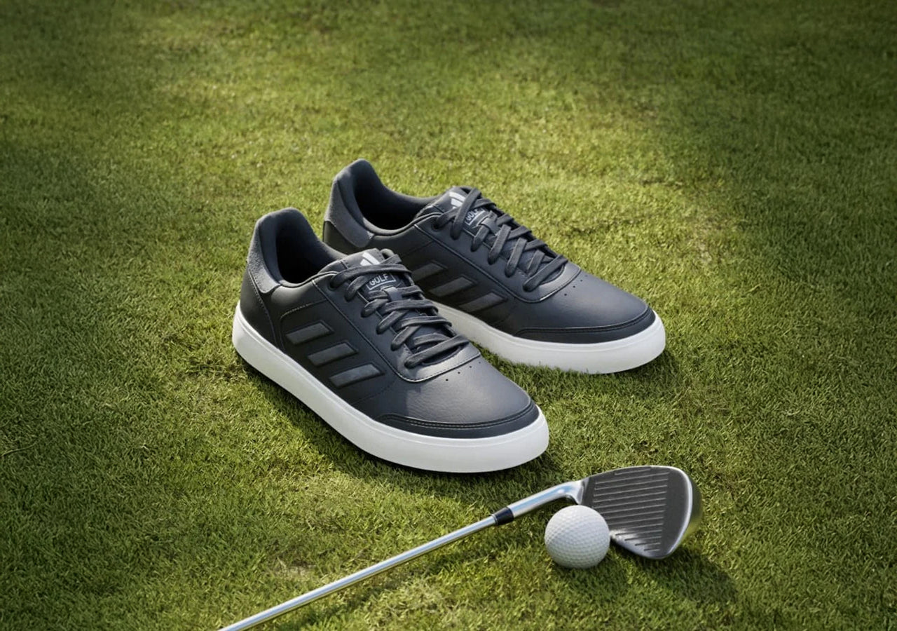 adidas retrocross golf shoes in the grass with a golf clubs and a golf ball