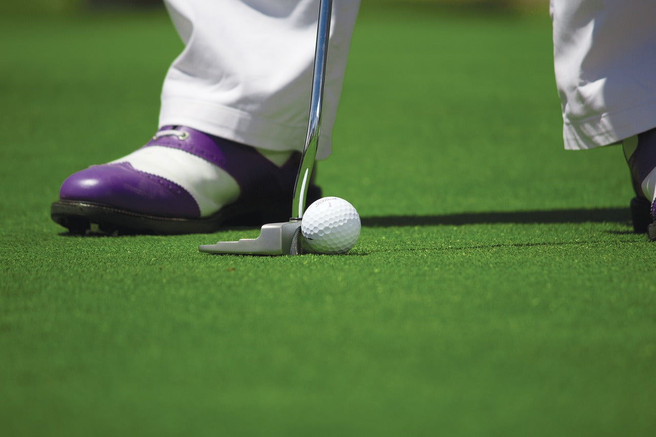 detail of a necessary golf shoe worn by a golf player while putting