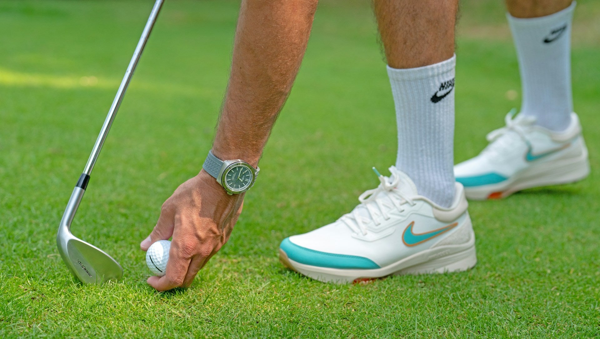 detail of a golf player wearing a comfortable golf shoe while adjust the ball for a hit