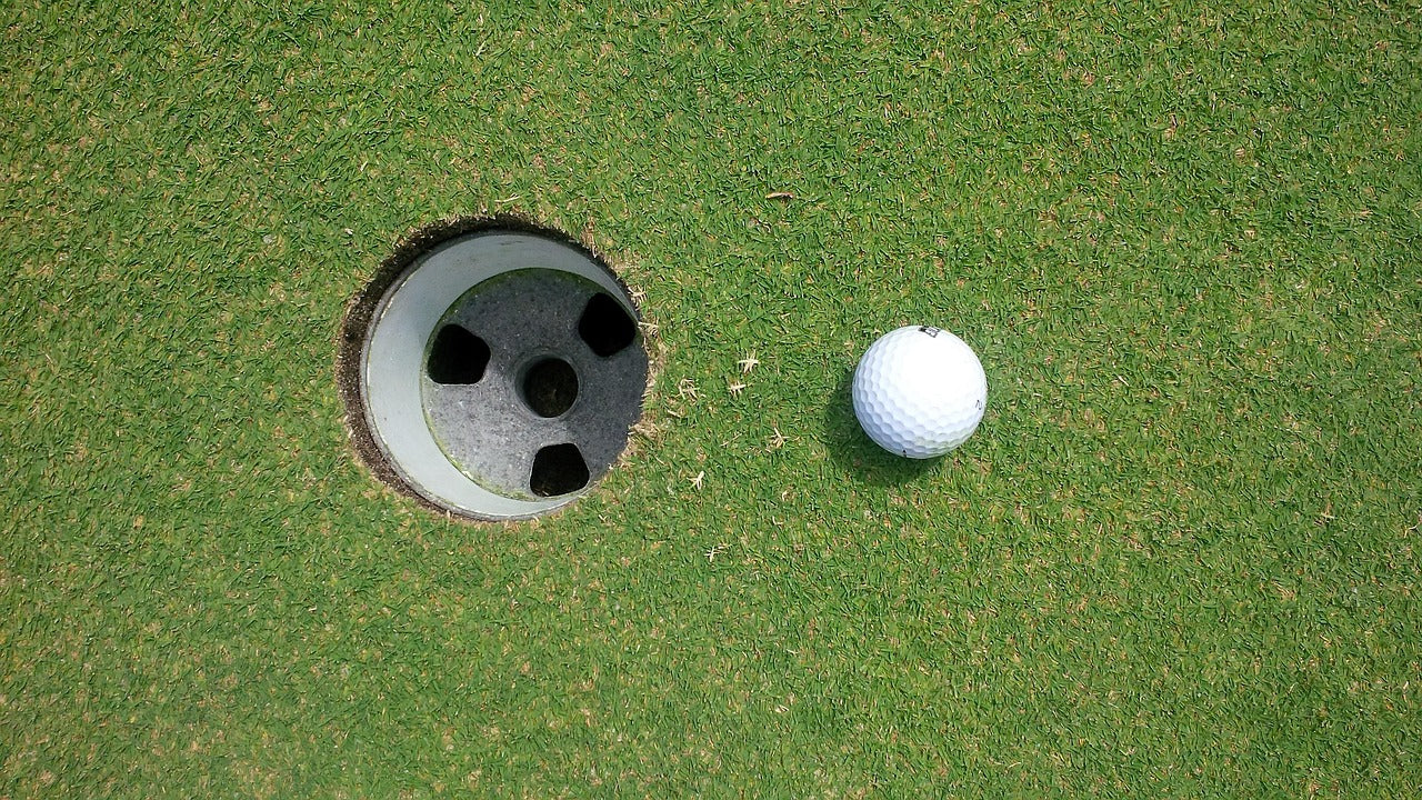 golf ball close to golf hole view from above