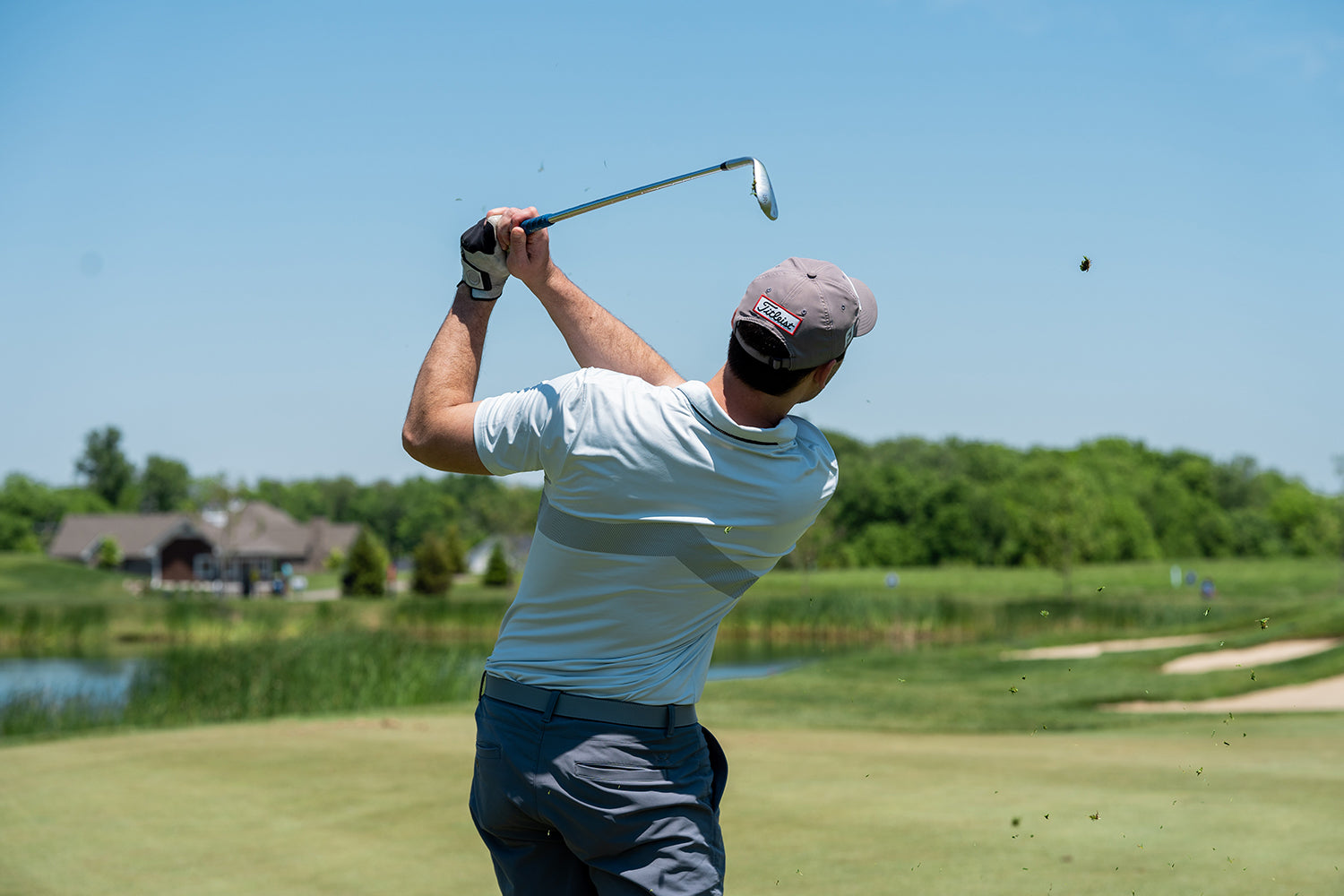 golf player wearing casual golf attire to a golf play hitting a ball on the green