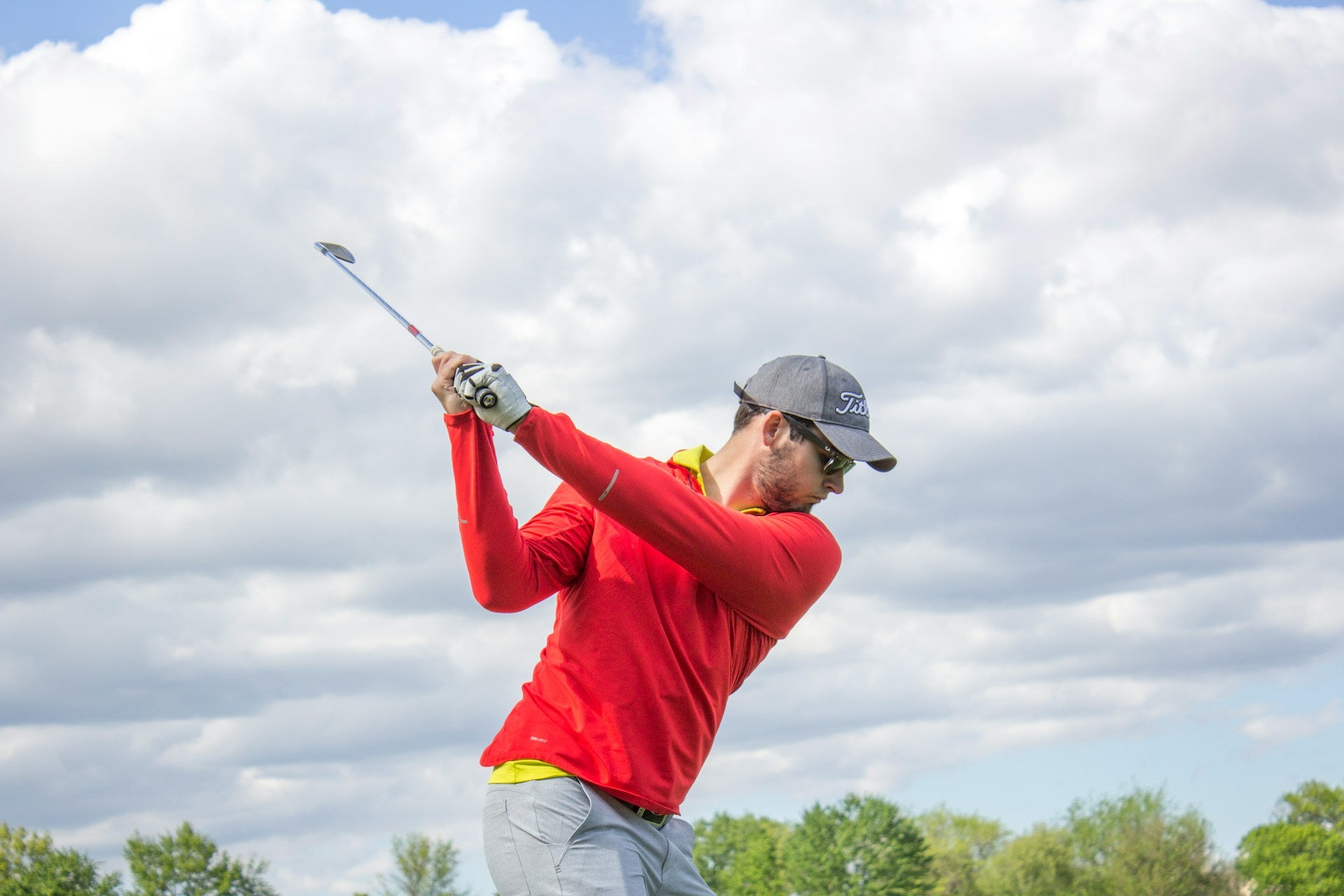 player wearing a golf shirt made of a proper material swinging a golf club