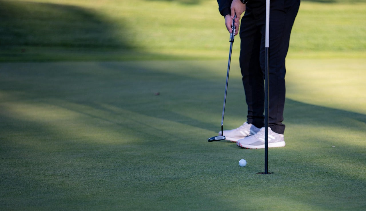 golf player putting ball with a putter golf club for beginners