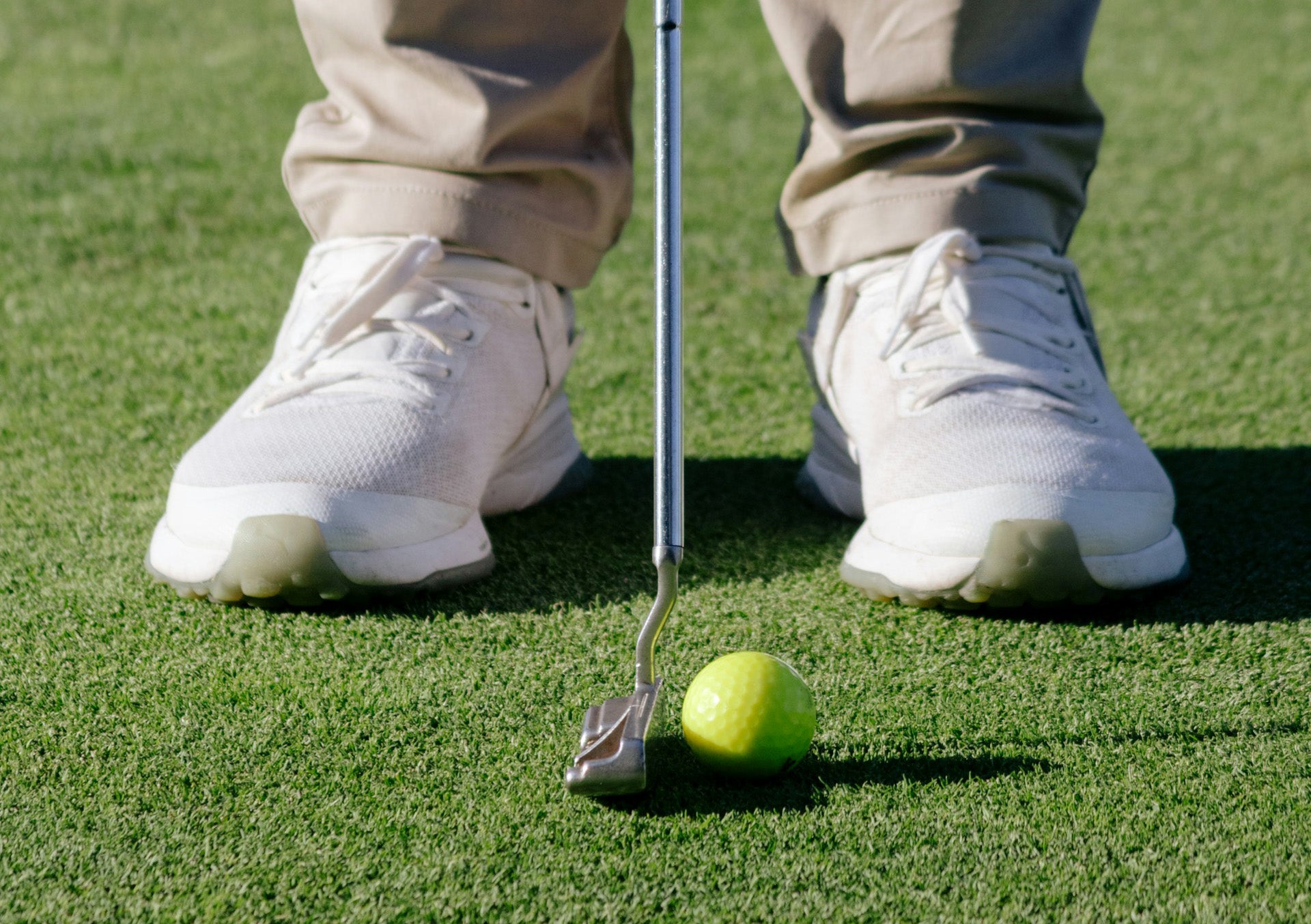 detail of the golf shoes worn by a player about to put a ball