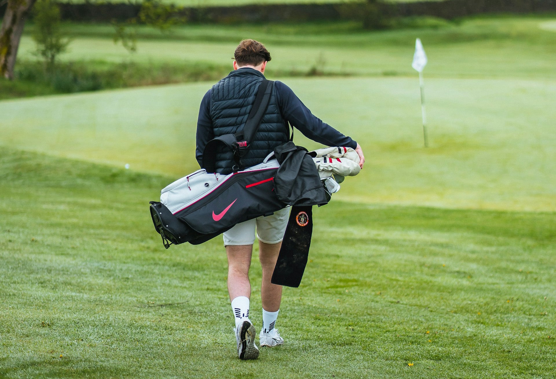 golfer carrying a golf bag with clubs weight