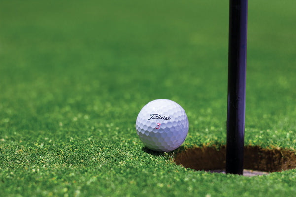 golf ball close to hole marking a birdie in golf score