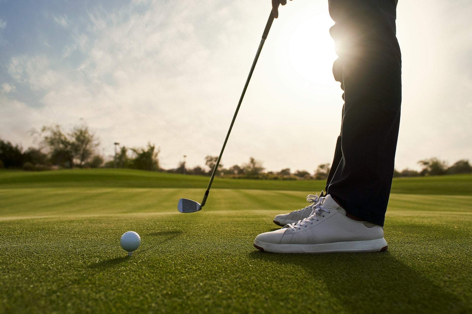 view of a player in a course wearing waterproof golf shoes under the sun