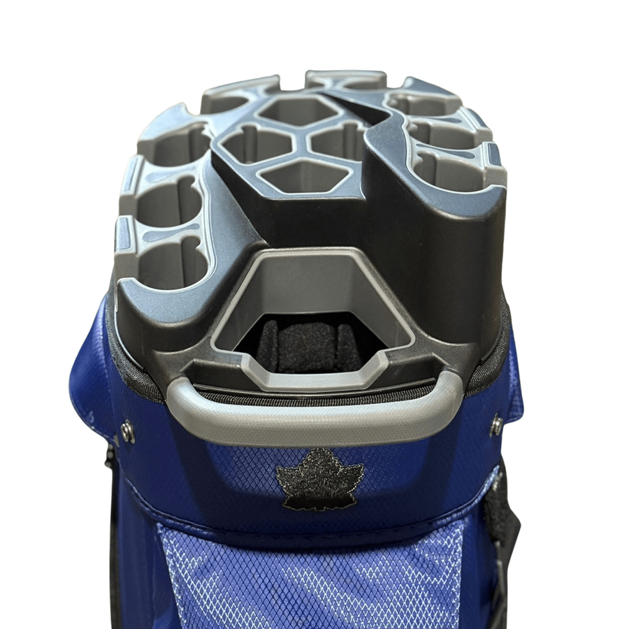 A close-up of the NS Deluxe Tour Lock Organizer Cart Bag in blue shows its 14-way divider with gray hexagonal and rectangular slots for organizing clubs, plus a maple leaf emblem below the handle.