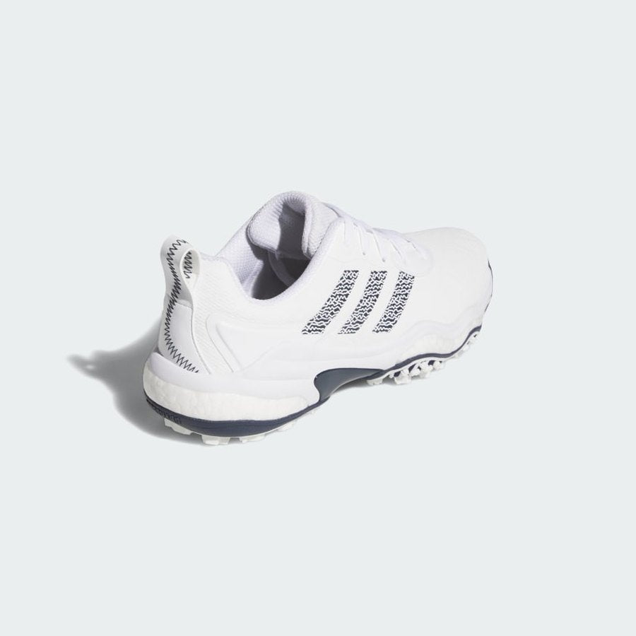 The Adidas Codechaos 25 Spikeless Golf Shoes in White/Navy, featuring a textured sole and crafted from recycled materials, are displayed from a rear-side angle on a light background.