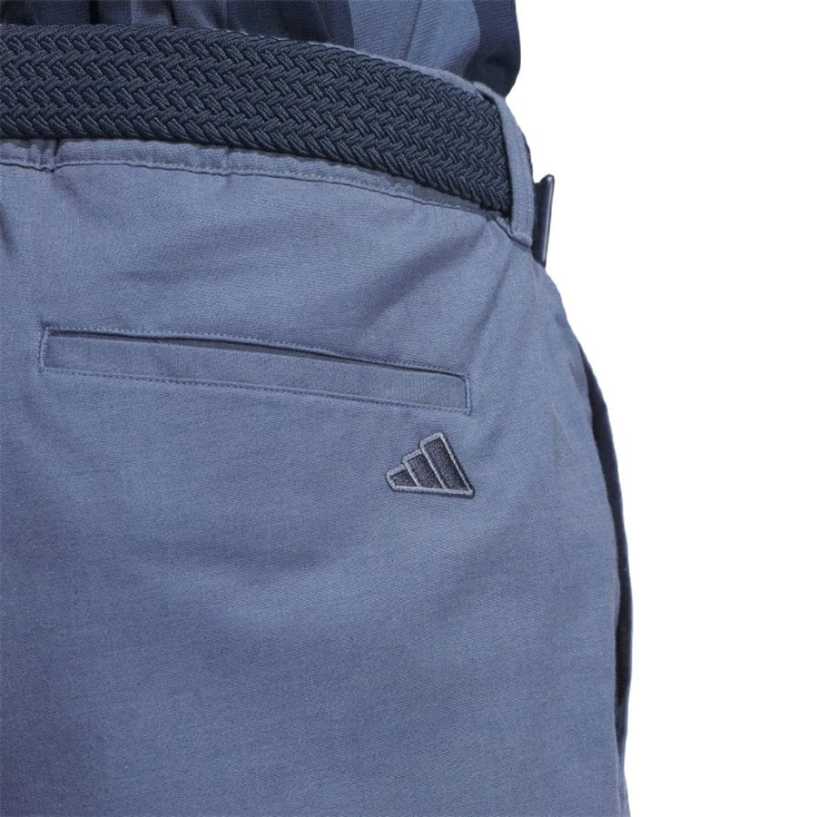 Close-up of the back pocket area of Adidas Go-To Versatile Pants in blue, featuring a textured dark blue belt and an embroidered Adidas logo by the pocket, crafted from recycled materials.