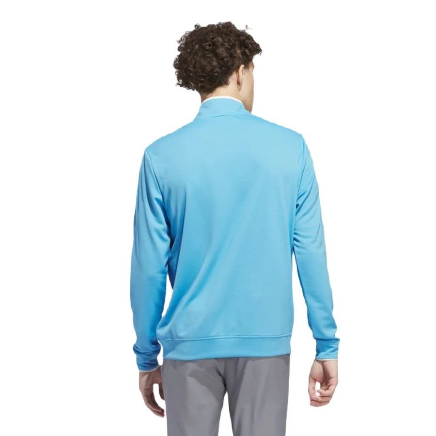 A man with curly hair is shown from the back, wearing a light blue Adidas Lightweight Half-Zip Top - Final Sale and gray pants against a white background.